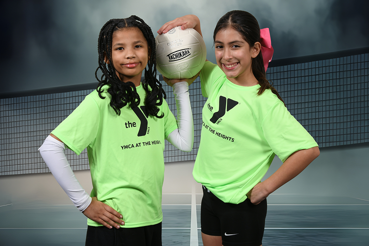 Two girls holding volleyball 